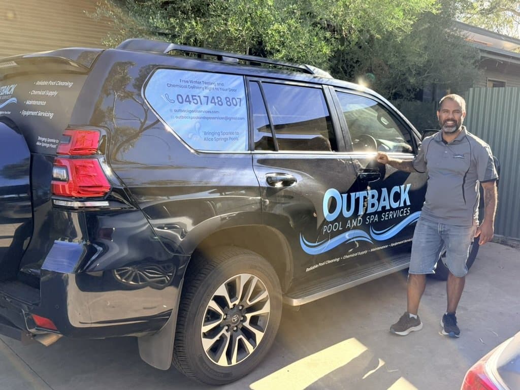 Owner standing beside an Outback Pool & Spa Services branded vehicle