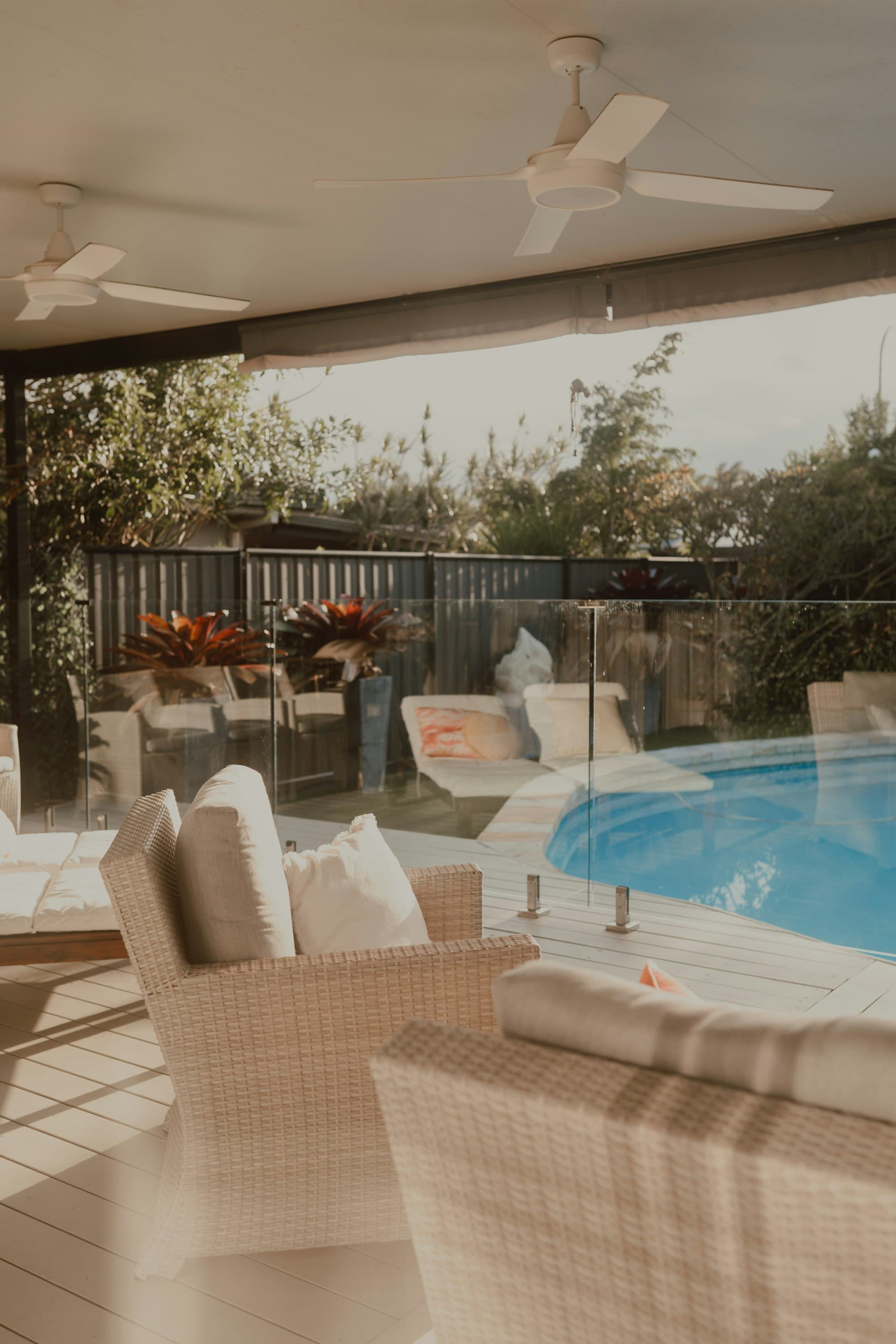 Modern residential swimming pool with glass fencing and timber deck