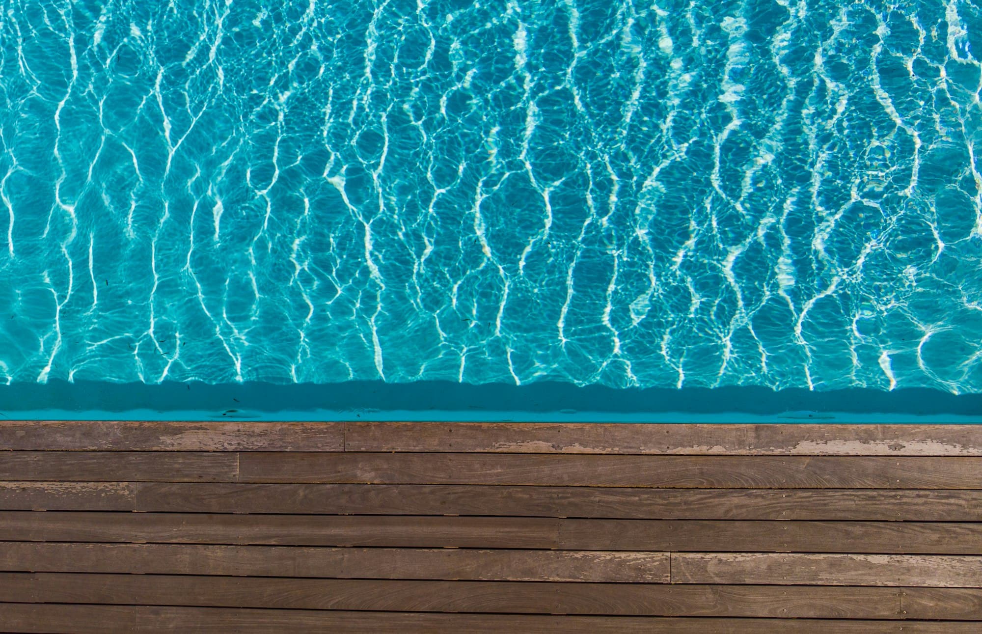 Close-up of pool water and timber deck edge